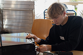 Ein Mitarbeiter repariert einen Drucker.